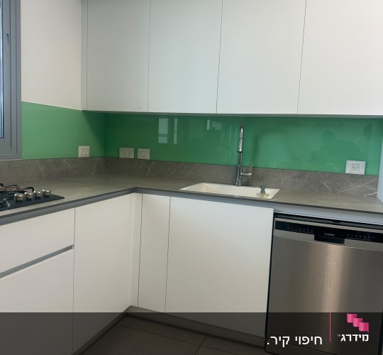מטבח עם חיפוי זכוכית ירוק וכיור נירוסטה